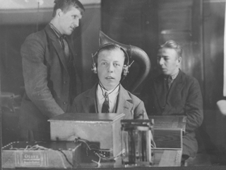 Historisk billede fra IBOS: Sort-hvid-billede af dreng med høretelefoner på.