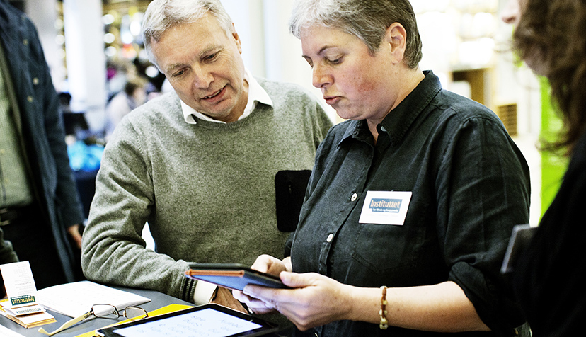 Birgit Christensen snakker med politiker Uffe Elbæk og viser hjælpemiddel. 