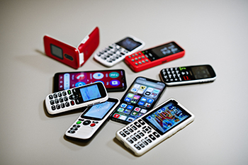 Mange forskellige telefoner ligger på et bord