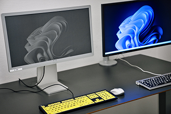 To computerskærme og tastatur med farvede taster